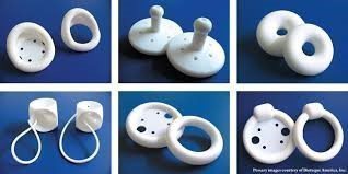 Various types of medical pessaries displayed on a blue background, including ring, cube, and dish-shaped designs.