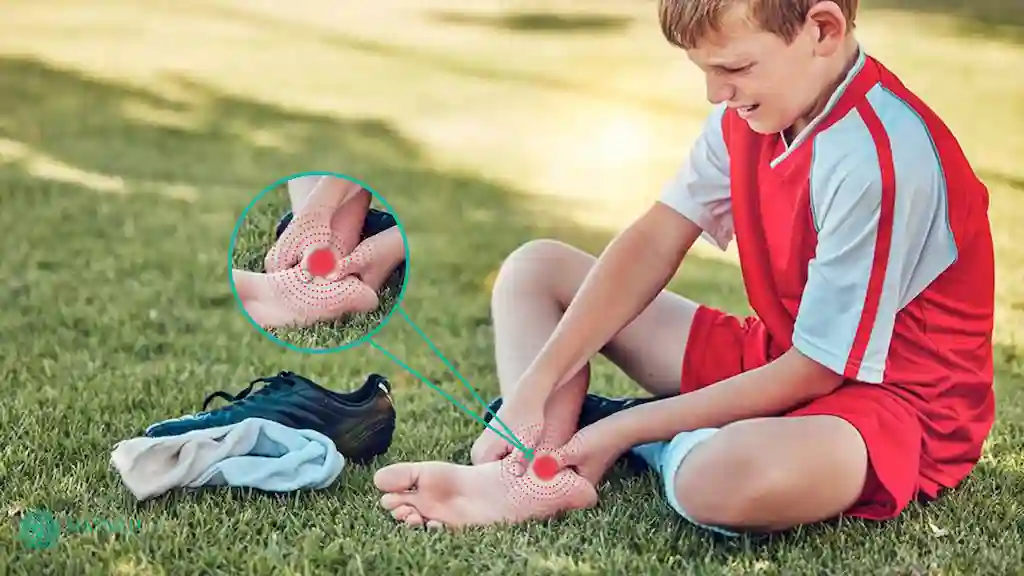 child athlete holding their heel in mild pain