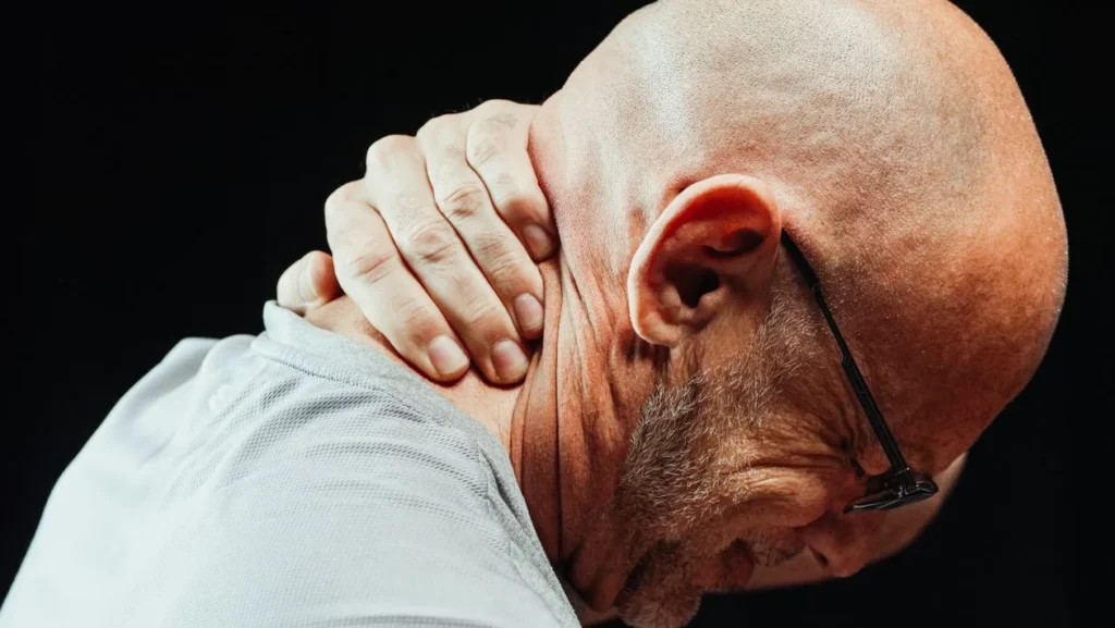 Man holding the back of his neck due to persistent pain and stiffness