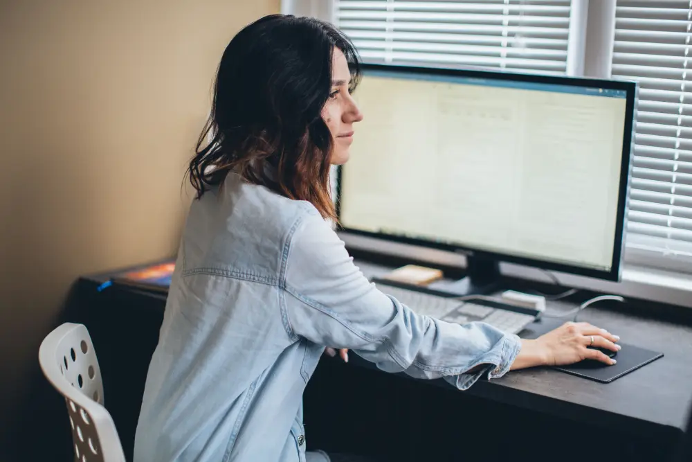 Office worker changing posture while working at a desk.