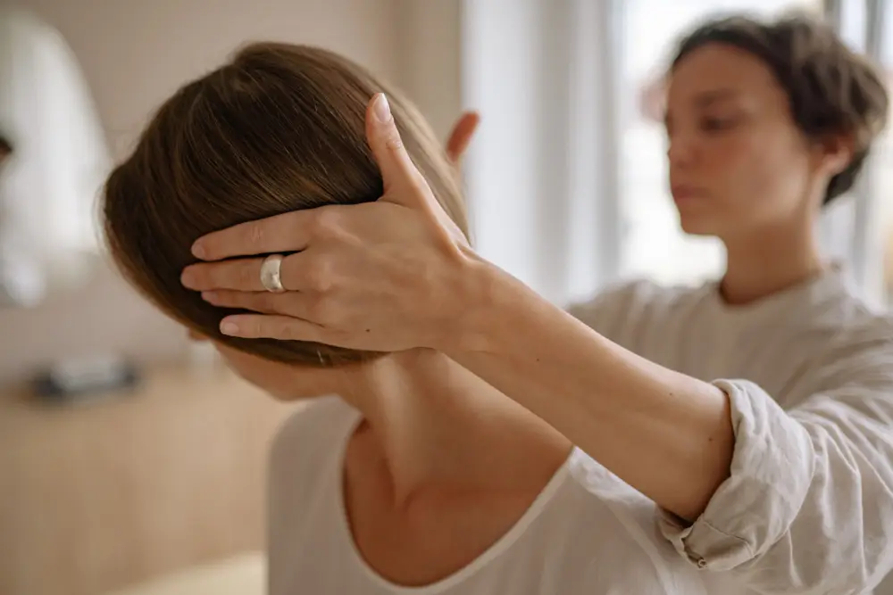 Chiropractor assessing neck function in a patient with headaches.